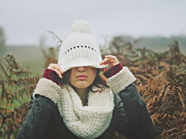 Frau zieht Mütze übers Gesicht